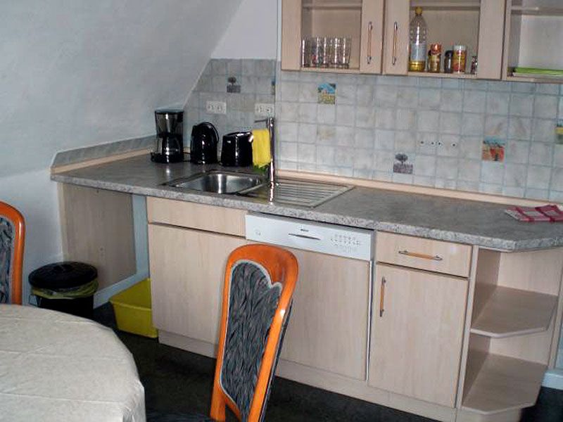 Voll ausgestattete Küche zur gemeinschaftlichen Nutzung. Großer Esstisch, Cerankochfeld, Mikrowelle, Geschirrspüler, Kaffeemaschine, Toaster, Wasserkocher